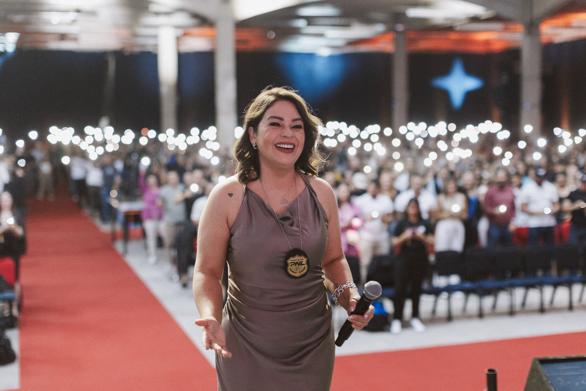 Jhoseâne no palco com microfone, conectando com o público